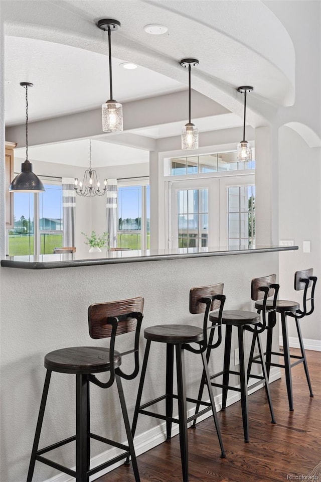 3048 Deer Creek Ranch Loop, Parker, CO 80138 - kitchen featuring dark wood-style floors, pendant lighting, a kitchen bar, recessed lighting, and arched walkways