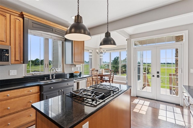 3048 Deer Creek Ranch Loop, Parker, CO 80138 - kitchen featuring a kitchen island, stovetop with downdraft, stainless steel microwave, french doors, and decorative light fixtures