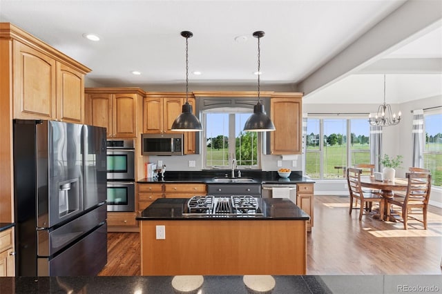 3048 Deer Creek Ranch Loop, Parker, CO 80138 - kitchen with appliances with stainless steel finishes, wood finished floors, a chandelier, dark countertops, and a kitchen island
