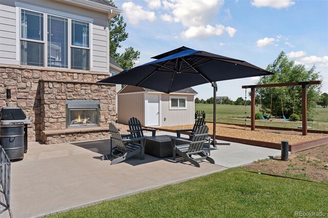3048 Deer Creek Ranch Loop, Parker, CO 80138 - view of patio featuring an outdoor stone fireplace, area for grilling, and a playground