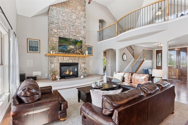 3048 Deer Creek Ranch Loop, Parker, CO 80138 - living room with stairs, healthy amount of natural light, a fireplace, arched walkways, and high vaulted ceiling