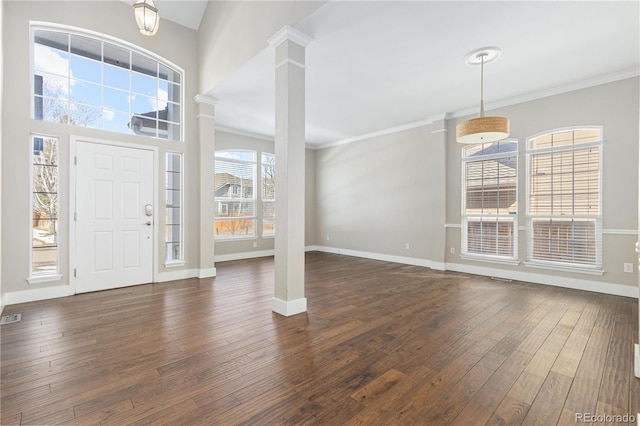 foyer with ornate columns, ornamental molding, dark hardwood / wood-style floors, and a towering ceiling