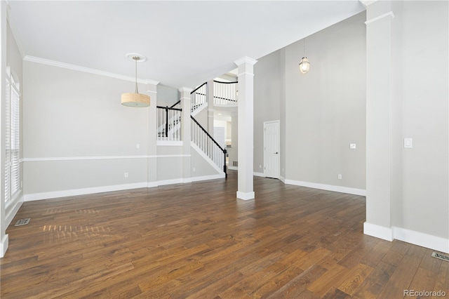 unfurnished living room with dark wood-type flooring, crown molding, and decorative columns