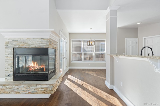 unfurnished living room featuring dark hardwood / wood-style floors, a healthy amount of sunlight, a fireplace, and sink