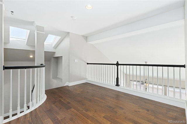 interior space featuring lofted ceiling with skylight and dark hardwood / wood-style flooring