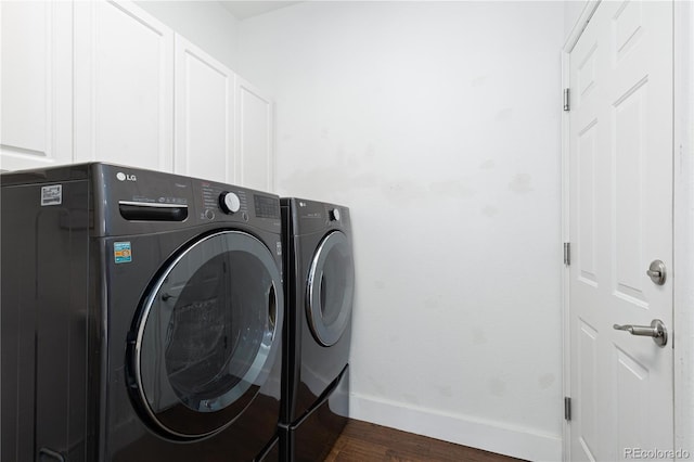 washroom with cabinets, washing machine and clothes dryer, and dark hardwood / wood-style floors