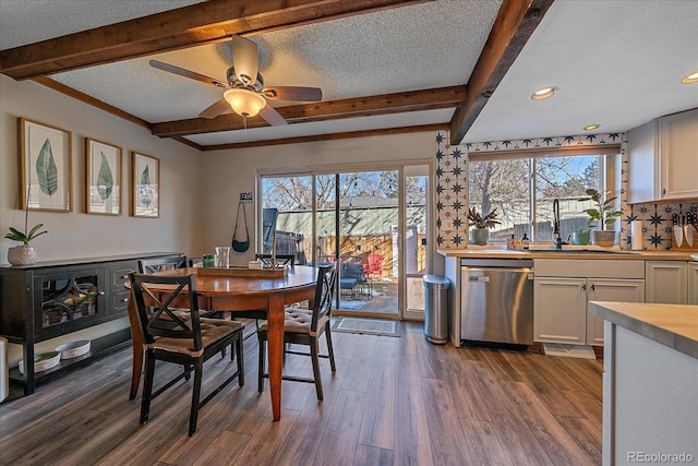 dining space featuring beam ceiling, sink, a textured ceiling, and dark hardwood / wood-style flooring