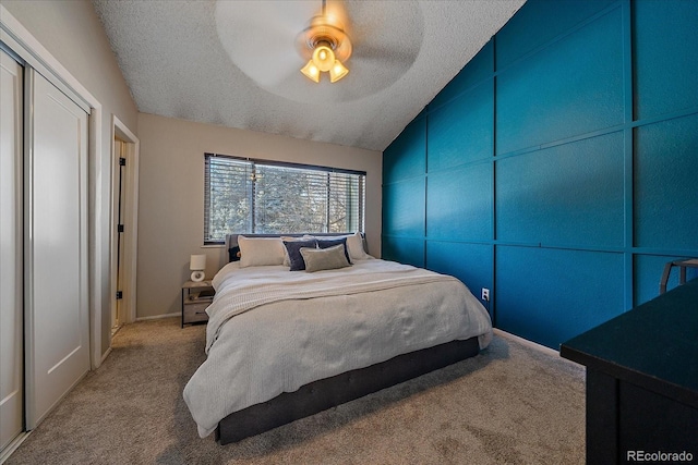 carpeted bedroom with ceiling fan, vaulted ceiling, and a textured ceiling