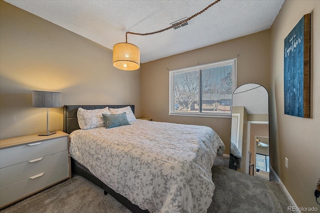 carpeted bedroom featuring multiple windows and a textured ceiling