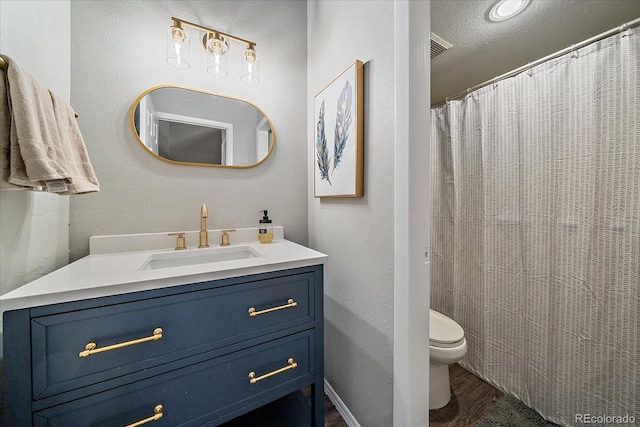 bathroom featuring vanity, toilet, hardwood / wood-style floors, and a textured ceiling