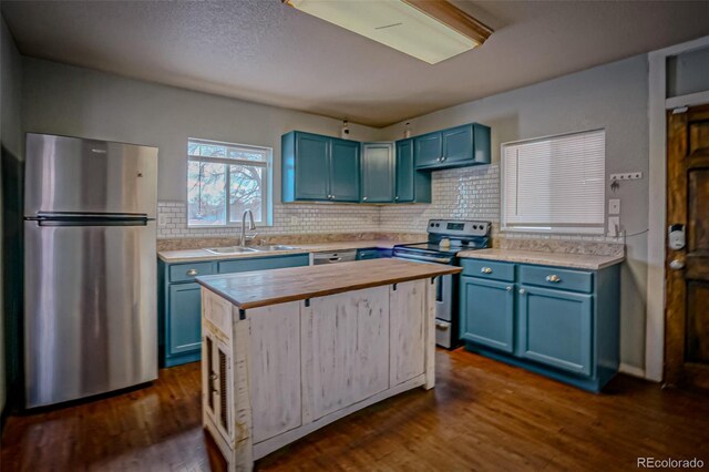 kitchen with blue cabinets, sink, tasteful backsplash, appliances with stainless steel finishes, and dark hardwood / wood-style floors