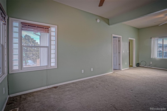 carpeted empty room with beam ceiling and ceiling fan