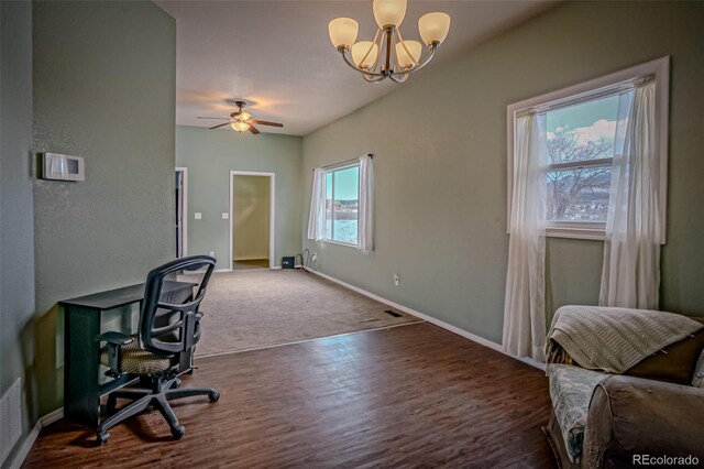 office space with dark wood-type flooring, a wealth of natural light, and ceiling fan with notable chandelier