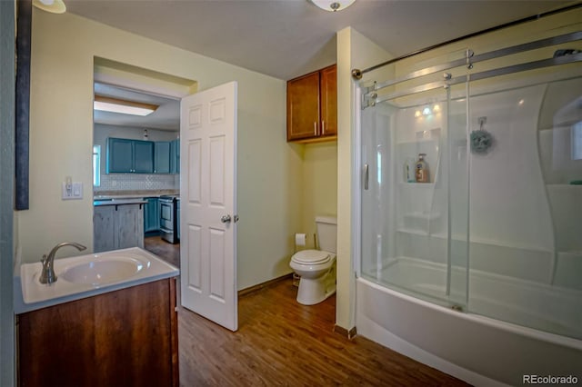 full bathroom featuring toilet, combined bath / shower with glass door, wood-type flooring, vanity, and backsplash