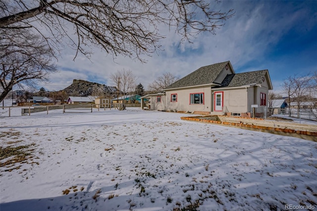 view of snow covered back of property