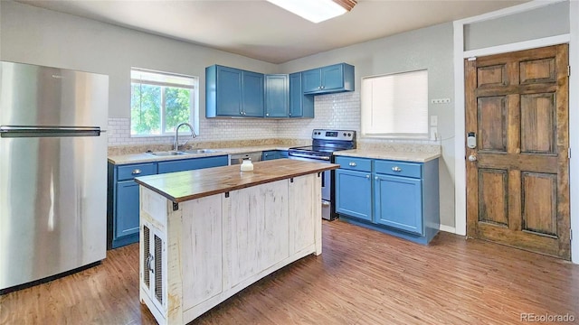 1205 N Linden Ave, Trinidad, CO 81082 - kitchen featuring appliances with stainless steel finishes, blue cabinetry, wood counters, and light wood-style flooring