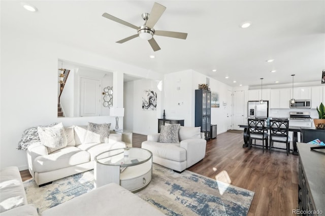 living room featuring dark wood-type flooring and ceiling fan