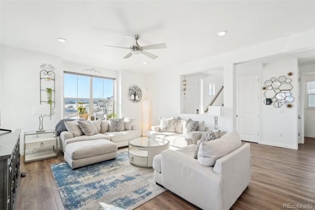 living room featuring ceiling fan and dark hardwood / wood-style floors