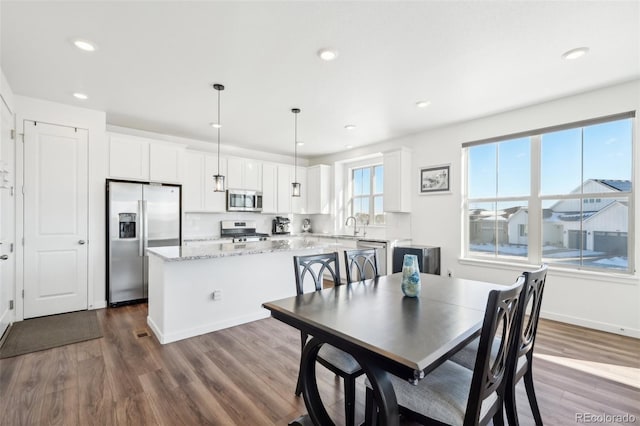 dining space with hardwood / wood-style floors and sink