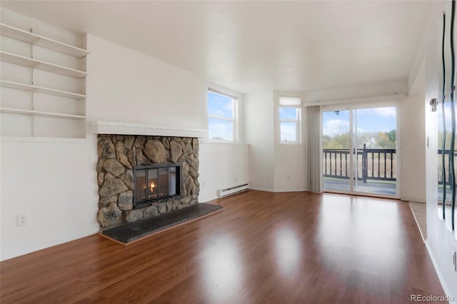 unfurnished living room with a fireplace, baseboard heating, and wood-type flooring