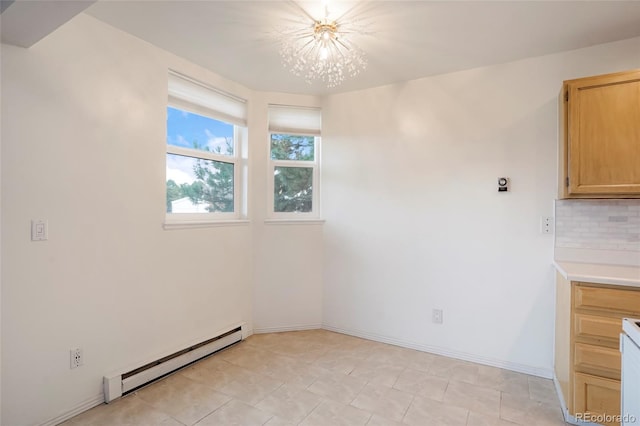 spare room with baseboard heating, light tile patterned floors, and an inviting chandelier