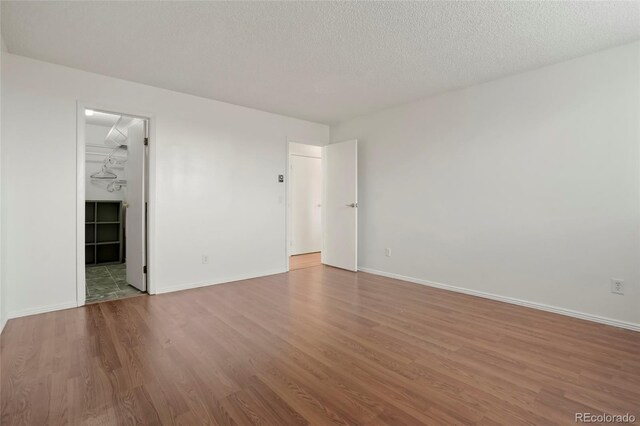 spare room with a textured ceiling and hardwood / wood-style flooring