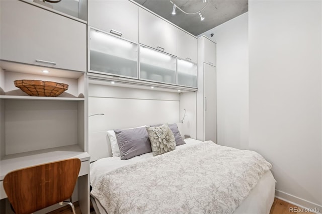 bedroom with wood finished floors and baseboards