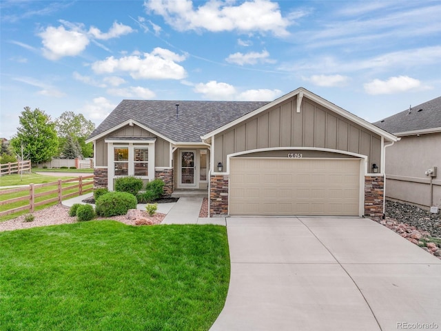 6015 Trappers Tale Ct, Colorado Springs, CO 80923 - view of front of house with stone siding, a shingled roof, driveway, and a garage