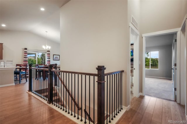 6015 Trappers Tale Ct, Colorado Springs, CO 80923 - corridor with an upstairs landing, wood-type flooring, plenty of natural light, vaulted ceiling, and a chandelier