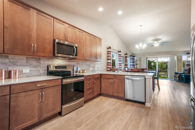 6015 Trappers Tale Ct, Colorado Springs, CO 80923 - kitchen with stainless steel appliances, open floor plan, vaulted ceiling, a peninsula, and light countertops