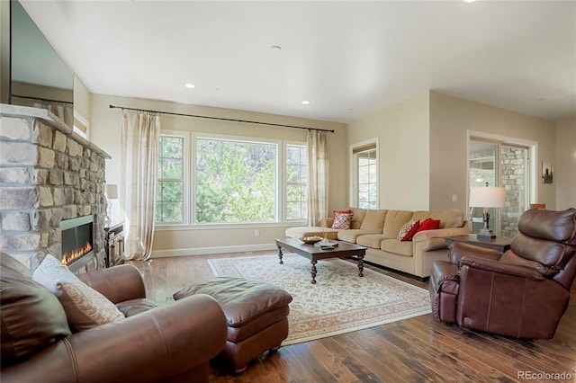 living area with wood-type flooring, baseboards, a fireplace, and recessed lighting