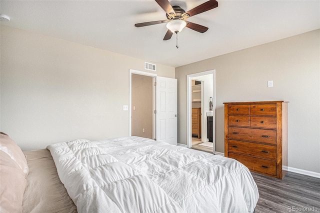 bedroom with visible vents, ensuite bathroom, ceiling fan, wood finished floors, and baseboards