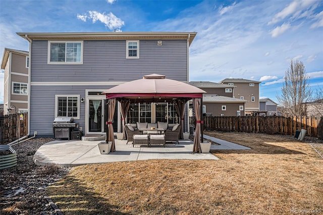 back of house featuring a patio area, a fenced backyard, an outdoor living space, and a gazebo