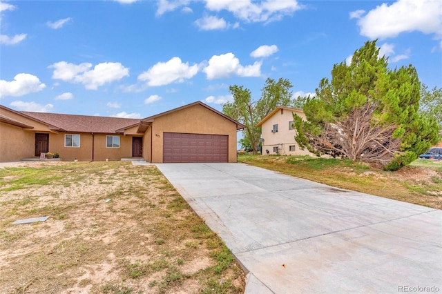 single story home with concrete driveway, an attached garage, and stucco siding