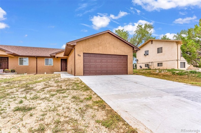 view of front of property with a garage, concrete driveway, and stucco siding