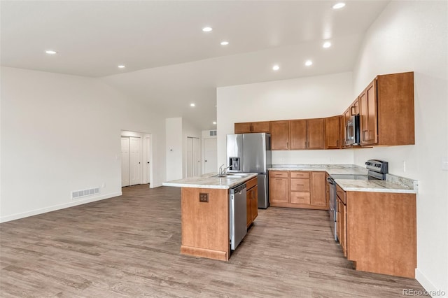 kitchen featuring high vaulted ceiling, visible vents, a kitchen island with sink, and appliances with stainless steel finishes