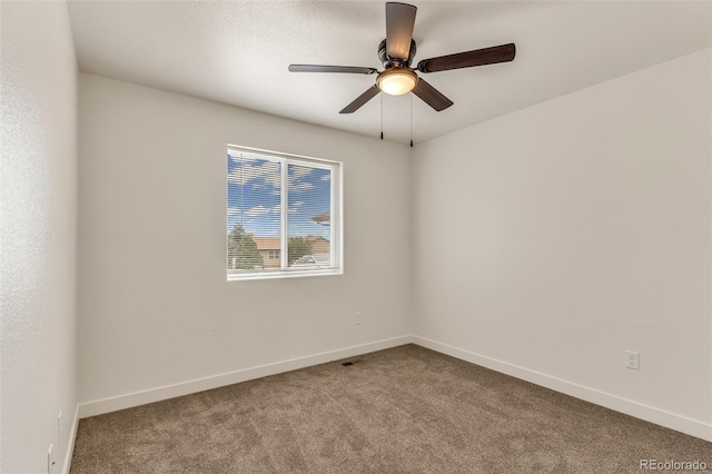 empty room with ceiling fan, carpet, and baseboards