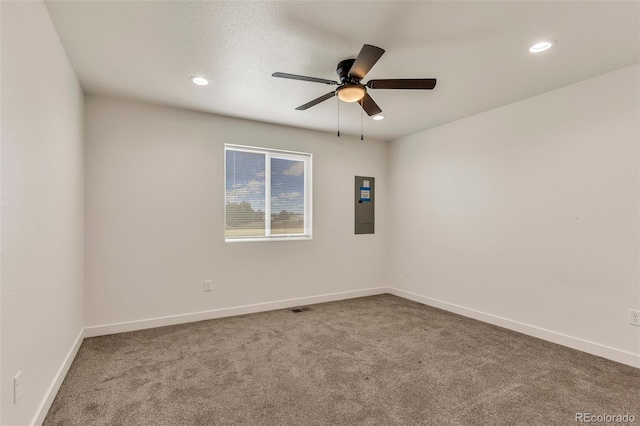 carpeted spare room with ceiling fan, electric panel, baseboards, and recessed lighting