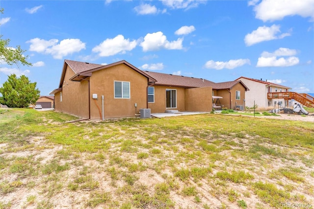 back of house featuring a patio area, stucco siding, a lawn, and central air condition unit