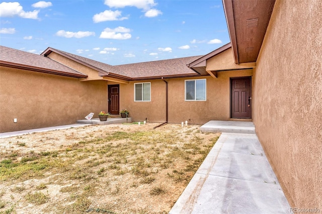 977 S Harmony Dr Unit 979, Pueblo, CO 81007 - view of exterior entry with stucco siding and roof with shingles