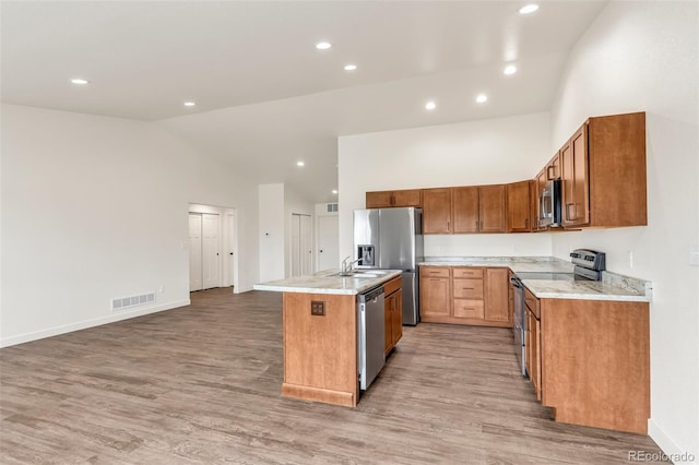 977 S Harmony Dr Unit 979, Pueblo, CO 81007 - kitchen featuring stainless steel appliances, high vaulted ceiling, a center island with sink, light wood-style flooring, and a sink
