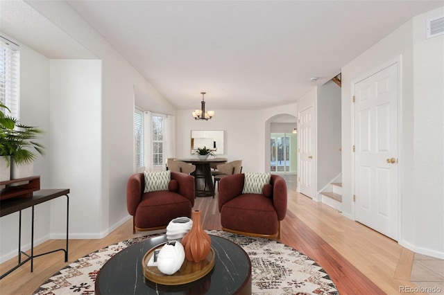 living room featuring a chandelier and light wood-type flooring