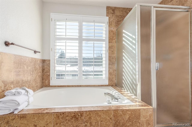 bathroom featuring independent shower and bath