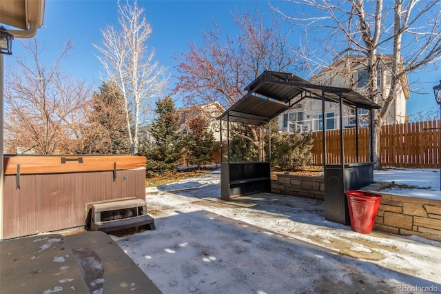 snow covered patio featuring a hot tub