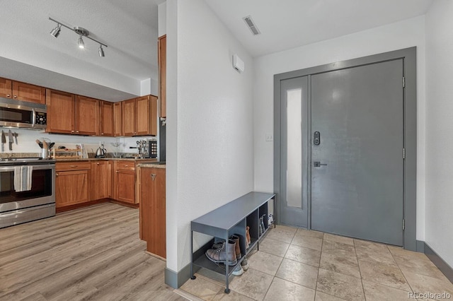 entrance foyer featuring visible vents, baseboards, and light wood finished floors