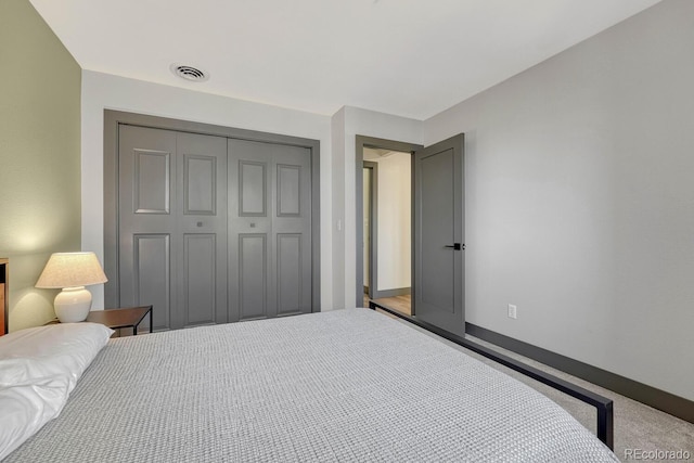 bedroom featuring a closet, visible vents, baseboards, and carpet floors