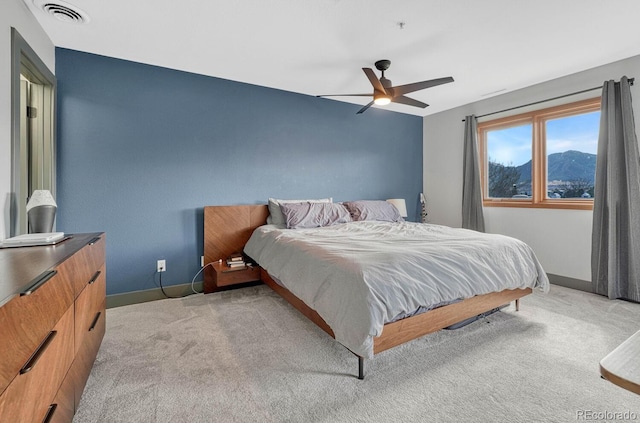 bedroom featuring visible vents, baseboards, light colored carpet, and a ceiling fan