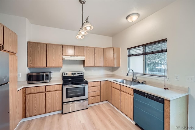 3033 W 107th Pl Unit D, Westminster, CO 80031 - kitchen featuring appliances with stainless steel finishes, a sink, light countertops, light wood-style flooring, and under cabinet range hood