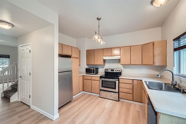 3033 W 107th Pl Unit D, Westminster, CO 80031 - kitchen with a sink, light wood finished floors, under cabinet range hood, stainless steel appliances, and a wealth of natural light
