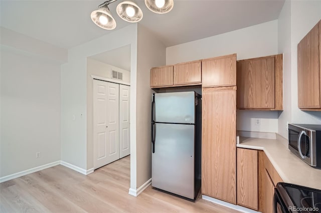 3033 W 107th Pl Unit D, Westminster, CO 80031 - kitchen featuring appliances with stainless steel finishes, light wood finished floors, light countertops, baseboards, and visible vents
